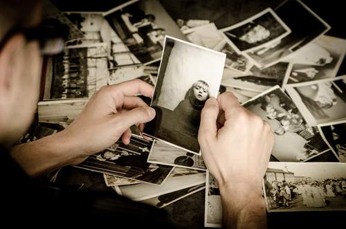 Een persoon bekijkt oude foto's. Bron: Pixabay.