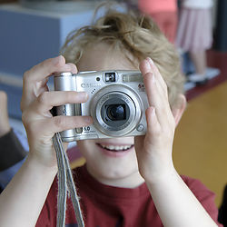 Jong kind houdt camera voor zijn gezicht. Fotograaf: Ben Nienhuis. Bron: Erfgoed Brabant.