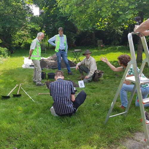Archeoloog en vrijwilligers bij een proefputje in tuin in Boxtel. CARE. Foto Erfgoed Brabant.